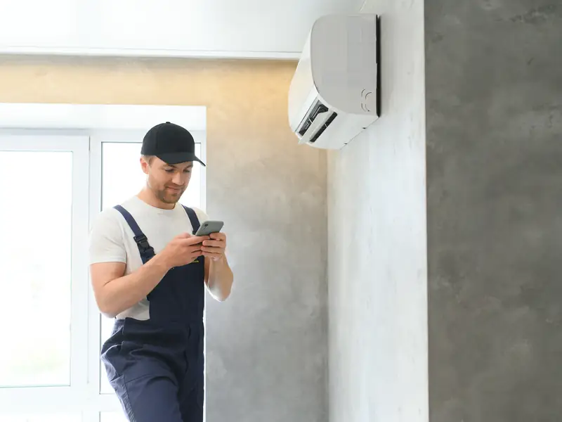 Climatisation à Cagnes-sur-Mer : pose, entretien et dépannage 3 Installateur contrôlant une unité intérieure qui vient d'être posée